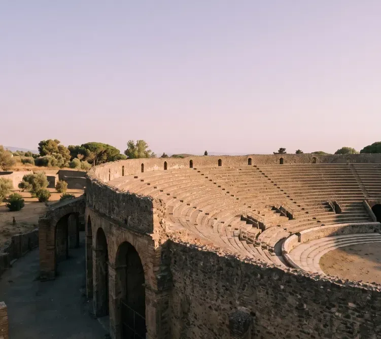 Vista panorámica del antiguo anfiteatro romano de Pompeya bajo la luz del atardecer.