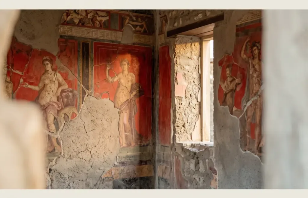 Fresco romano perfectamente conservado bajo la ceniza en Pompeya. Colores vibrantes y texturas agrietadas.